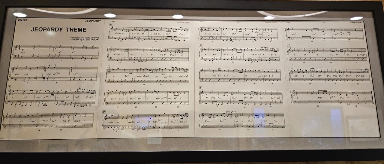 The 'Jeopardy!' theme music, framed on the wall