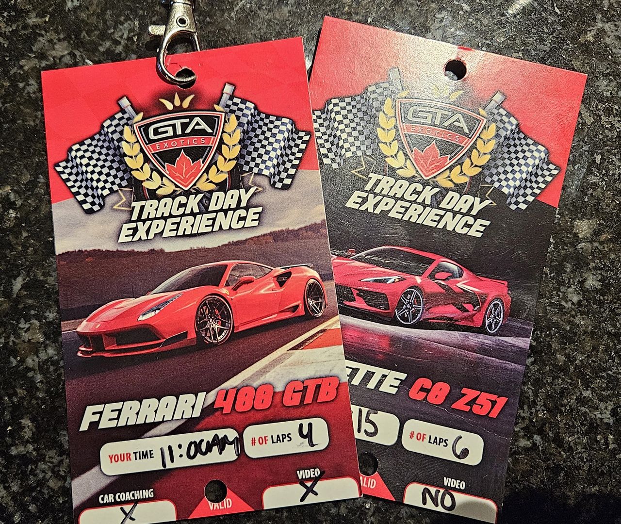 2 Lanyards on a table. one for the Ferrari, one for the Corvette