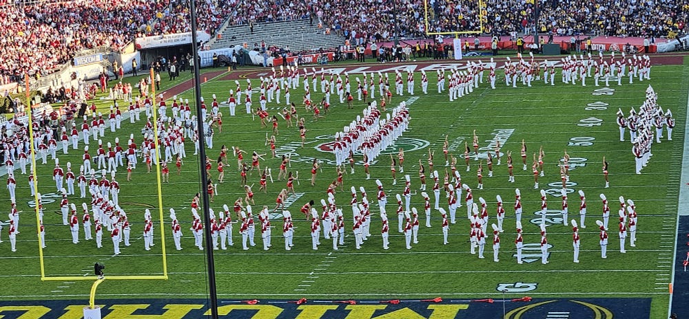 Red and white clad Alabama marching band and cheerleader squad perform during halftime at the rose bowl.