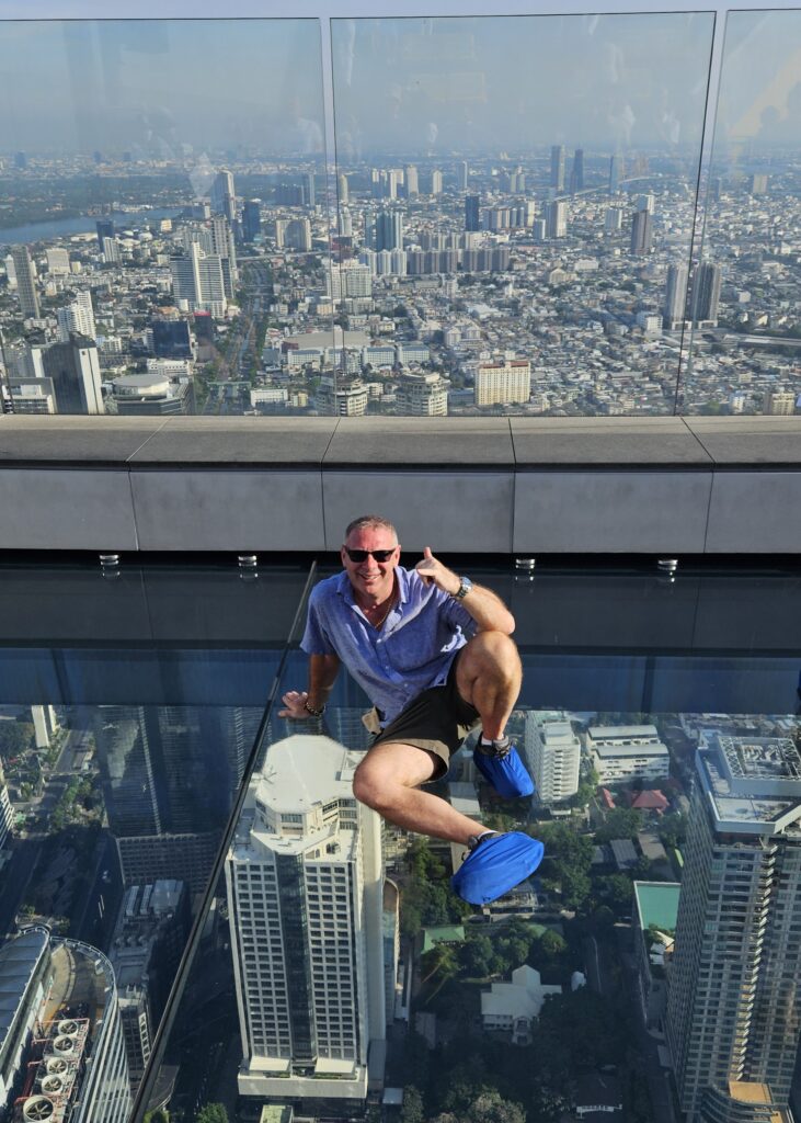 A man sits on a glass floor 78 stories above Bangkok