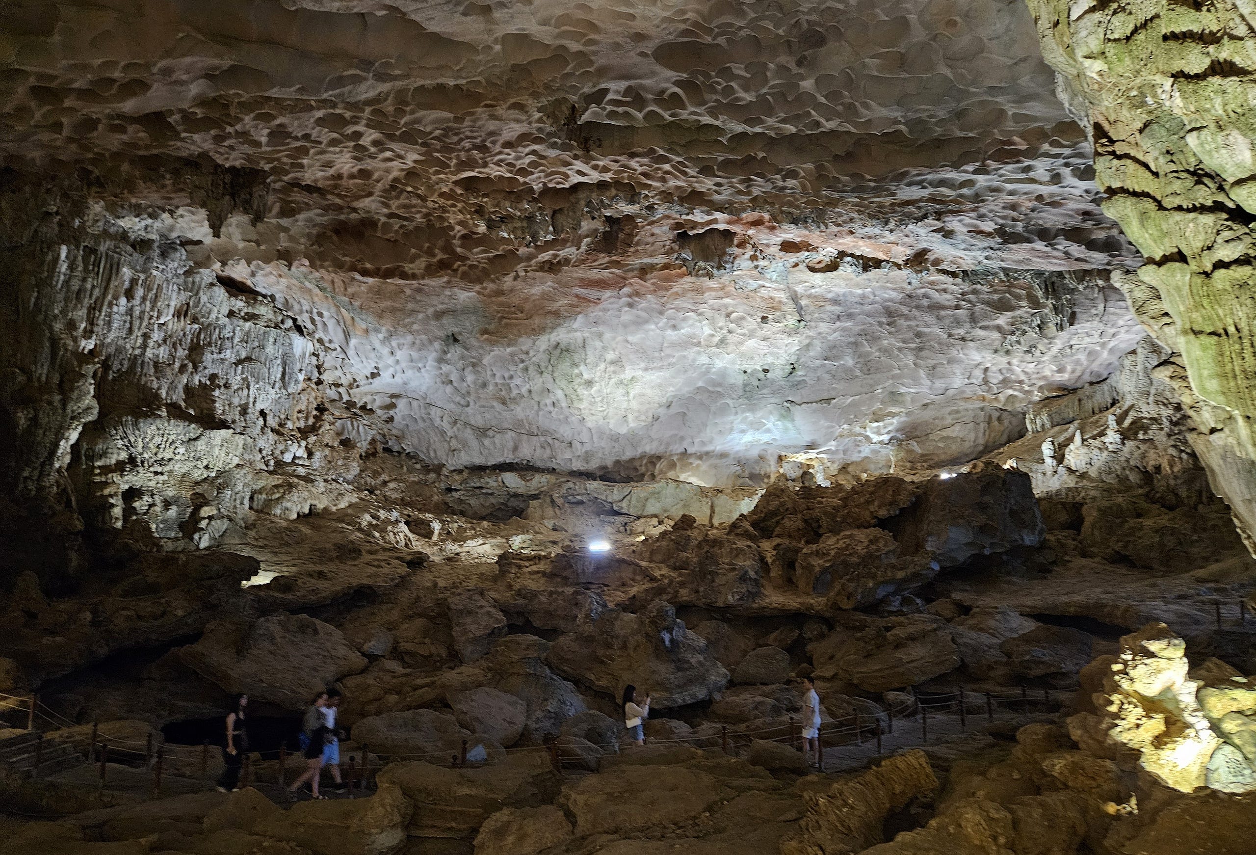 People follow a path through the massive central cavern in Sang Hung Sot Cave in Ha Long Bay, Vietnam