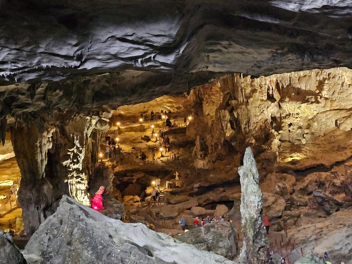 People follow a path through the Sang Hung Sot Cave in Ha Long Bay, Vietnam