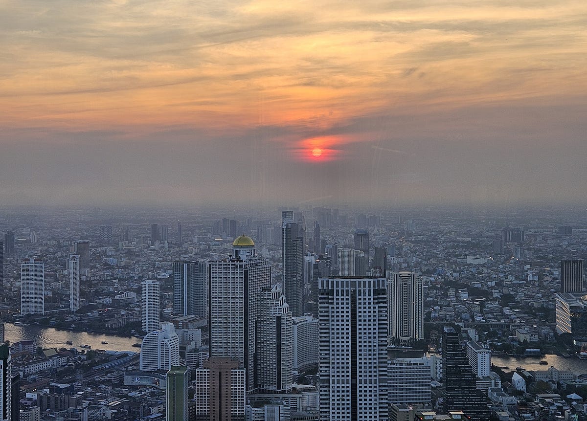 The sun sets over the Bangkok skyline.