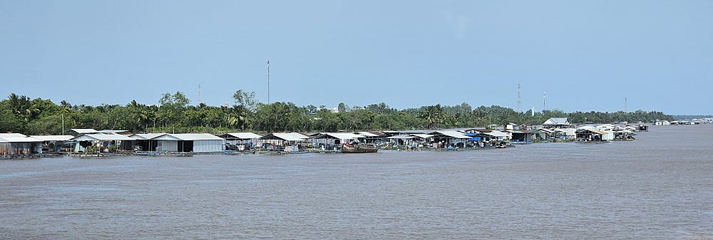 Floating village of small houses in the Mekong River.