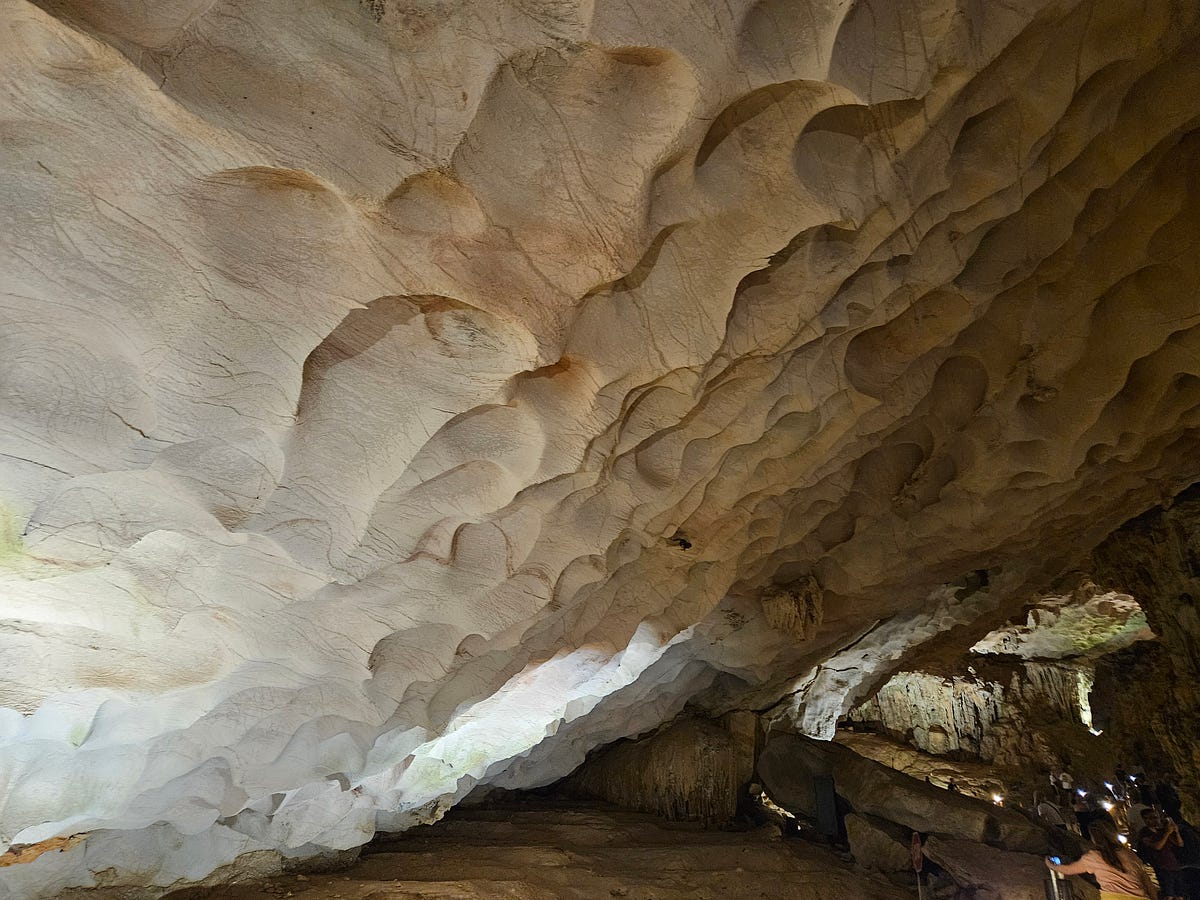 A close-up picture of the cave ceiling. Divots, holes, and peaks formed in the limestone at the caves at Ha Long Bay