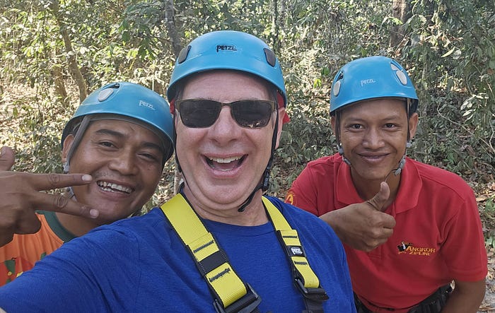 3 men wearing funky blue helmets pose for a picture