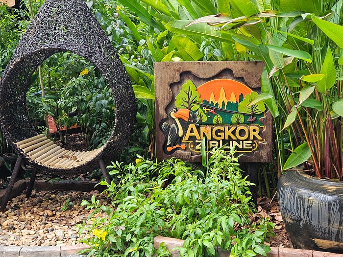 A funky round chair and the sign for Angkor Zipline.