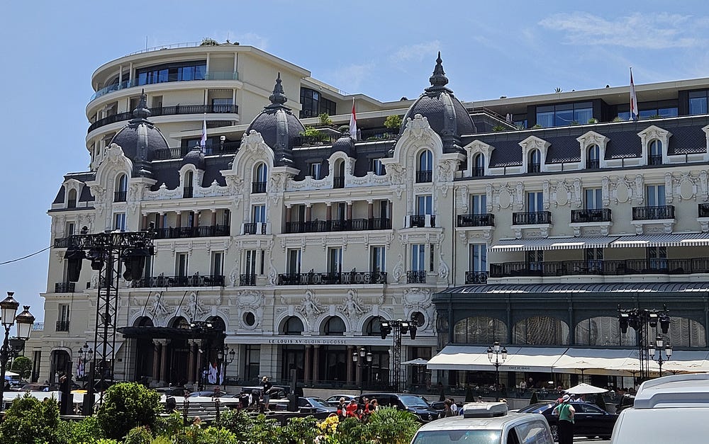 A beautiful 5 story hotel in Monaco. White stone with a dark roof.