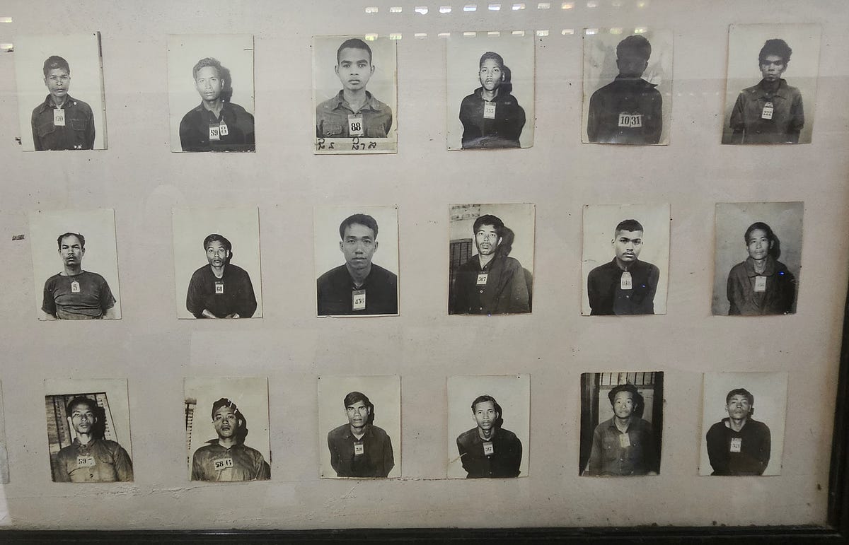 A large board holds black and white pictures of prisoners kept at the prison.