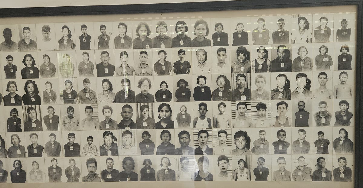 A large board covered with rows of black and white prisoner photos.